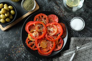 Fototapeta na wymiar Concept of tasty food with tomato carpaccio on black smokey table