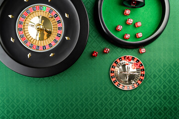 Casino. Gambling games theme.  Roulette wheel, dice and poker chips on the casino felt green table.