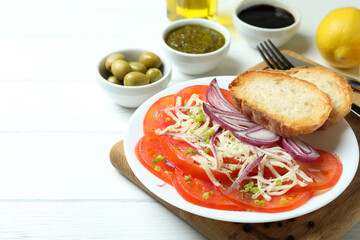 Concept of tasty food with tomato carpaccio on white wooden table