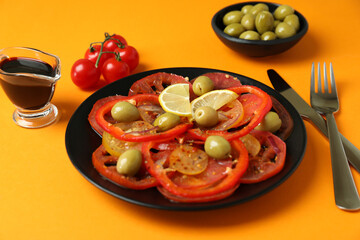 Concept of tasty food with tomato carpaccio on orange background