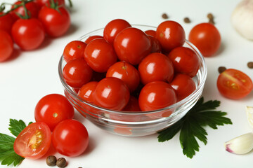 Bowl with pickled tomatoes and ingredients on white background