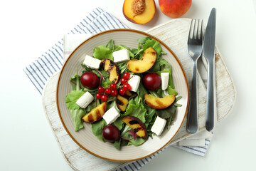 Concept of tasty food with salad with grilled peach on white background