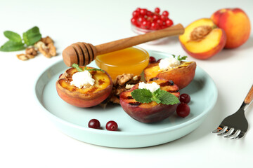 Concept of tasty salad with grilled peach on white background