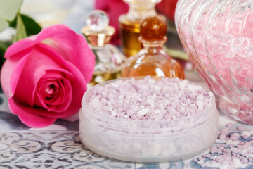 Bowl with a lavender sea salt. Roses and other cosmetics around it.