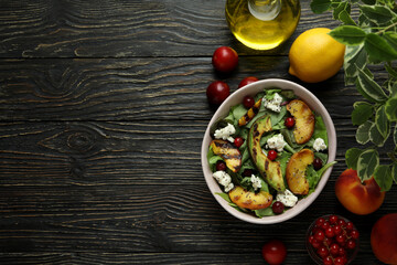 Concept of tasty food with salad with grilled peach on wooden table