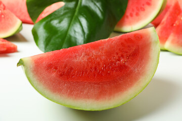 Juicy watermelon slices and palm leaf on white background