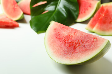 Juicy watermelon slices and palm leaf on white background