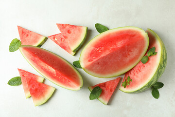 Watermelon slices and mint leaves on white textured table