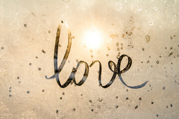winter glass with sun, inscription love on frozen glass, Valentine's Day card