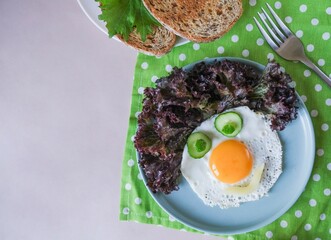 Fun Food for kids - a smiling face made from scrambled eggs, cucumbers, corn, bell pepper for a healthy breakfast for children
