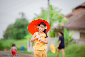 Close-up background view of a blurred Asian girl running or teasing in the street in front of the...