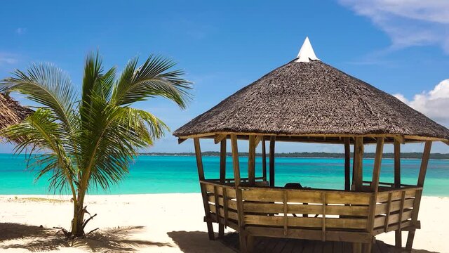 Bungalow on a tropical beach with palm trees and blue sea of Daco, Philippines. Summer and travel vacation concept
