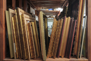 Wooden shelves at art gallery storage full of pictures and art equipment