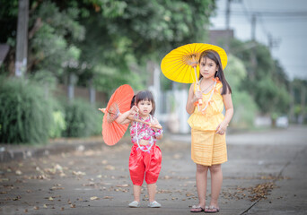 Close-up background view of two young Asian girls running or teasing in blur on the street in front...