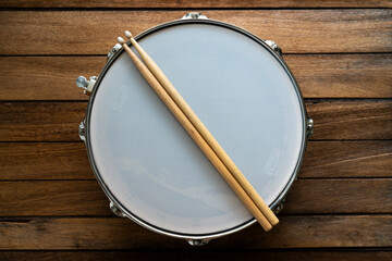Drum stick and drum on wooden table background, top view, music concept - obrazy, fototapety, plakaty