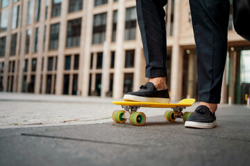 Fototapeta premium An entrepreneur rides a skateboard to work in the morning. The lawyer holds a bag with documents in his hand. The manager is rushing to a meeting in a business suit.
