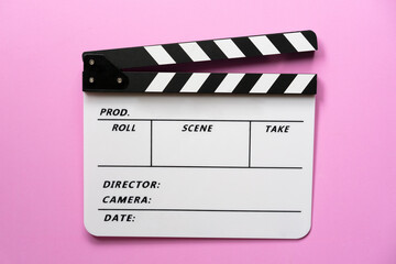 movie clapper on pink table blackground ; film, cinema and video photography concept