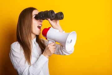 Friendly young woman holds a megaphone in her hands and looks through binoculars on a yellow background. Hiring concept, help wanted. Banner