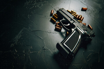 Pistol with bullets on concrete table. Black gun and brass cartridges. Firearms close-up. Weapon of crime. Means of defense or attack. Copy space for text.