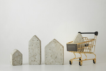 House model in mini shopping cart on the white background. Buy a house. Concept for property...