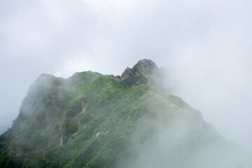 雄大な山と小さなハイカー