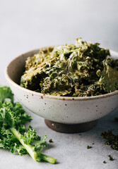 Kale chips in a ceramic bowl, selective focus