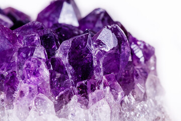 Macro mineral stone purple amethyst in crystals on a white background