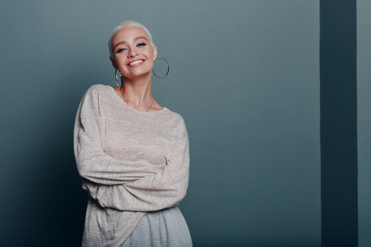 Millenial young woman with short blonde hair smiling portrait copy space