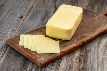 Kashar cheese or kashkaval cheese on wood floor. Cheese slices on the serving board