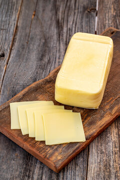 Kashar cheese or kashkaval cheese on wood floor. Cheese slices on the serving board