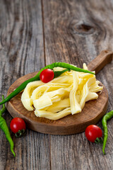 Chechil cheese or string cheese on wood floor. Cheese on serving board