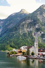 Fototapeta premium Vertical view of the Evangelische Pfarrkirche Hallstatt, with the alpine mountains behind it.