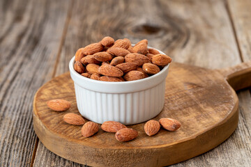 Almond nuts on wood background. Organic and fresh nuts. Almonds in a plate. close up