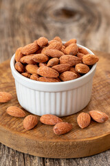 Almond nuts on wood background. Organic and fresh nuts. Almonds in a plate. close up