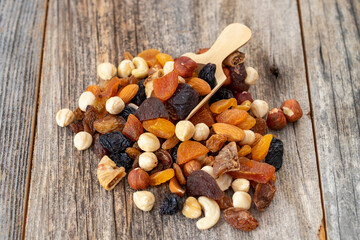 Mixed nuts on wood floor. Organic and fresh nuts. Wooden spoon on top of nuts. close up