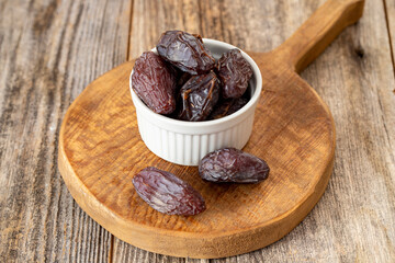 Date fruit in a plate. Date fruit on wood background. Organic and fresh nuts. close up