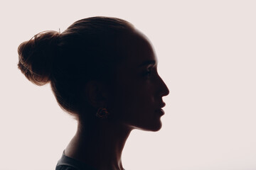 Fototapeta premium Adult young woman silhouette profile portrait in studio