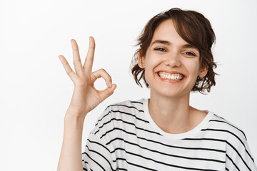 Close up of happy smiling woman showing ok, okay sign in approval, like and agree, praise excellent...