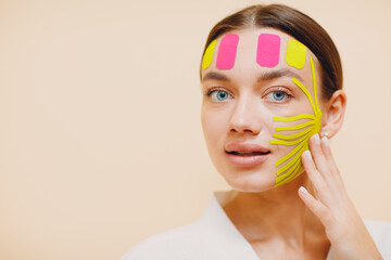 Beautiful woman applying tape lifting treatment procedure on face - obrazy, fototapety, plakaty
