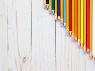 Multicolored pencils on the wooden table