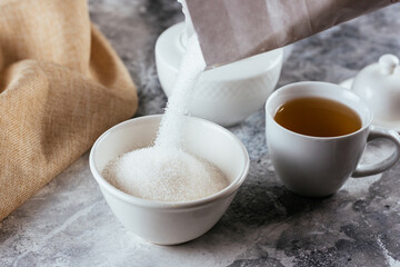 white sugar in a ceramic bowl on a marble background