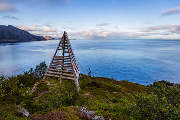 Scenic view mountains, sea and wooden pyramid on the trail from Nosfjord till Nesland village...