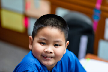 Portrait of cute smiling Asian boy with short black hair