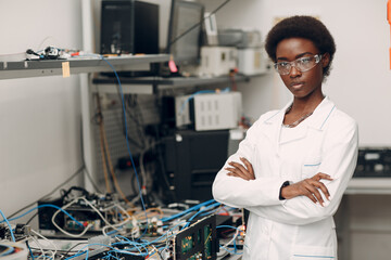 Scientist african american woman standing and looking at camera in laboratory with electronic tech...
