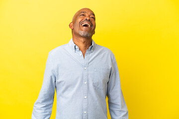Cuban Senior isolated on yellow background laughing