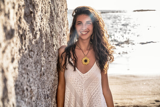 Natural beautiful italian woman smiling to the camera, enjoying sunny day on the beach.