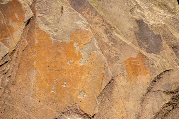 Raw rock in orange with minerals and metals as natural stones background with crushed and rough material at a rough coast or rocky beach show stone quarry and sandstones in broken surface granite form
