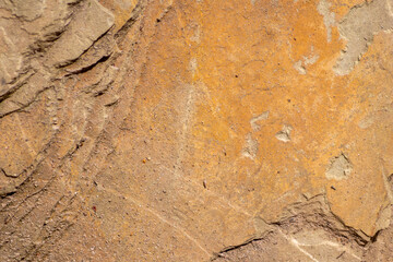 Raw rock in orange with minerals and metals as natural stones background with crushed and rough material at a rough coast or rocky beach show stone quarry and sandstones in broken surface granite form