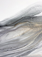 Abstract grey art with gold — black and white background with beautiful smudges and plisse made with alcohol ink and golden paint. Grey fluid texture resembles marble, smoke, watercolor or aquarelle.

