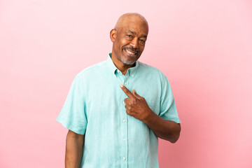 Cuban senior isolated on pink background with surprise facial expression
